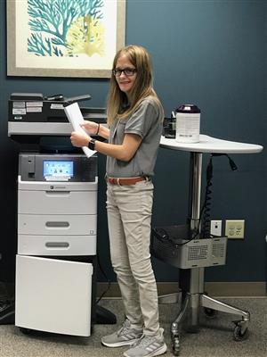 Intern Kelly Miller stocks a printer 